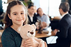 Child holding stuffed animal in legal office 