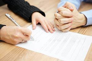 Couple signing postnuptial agreement 