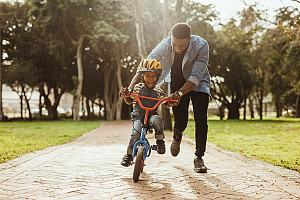Father teaching son how to ride bike