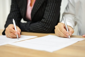 couple signing papers in divorce mediation