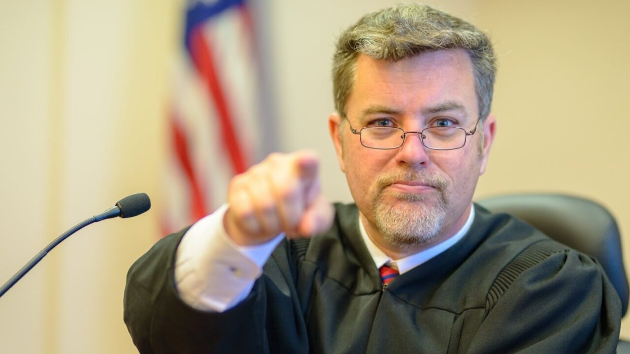 male judge pointing in courtroom