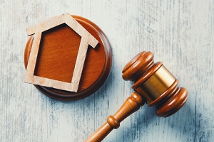 gavel and houses on a wooden background