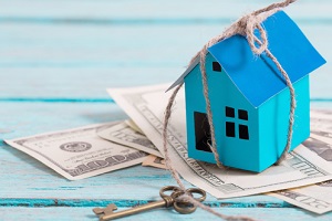 house from the paper and money on wooden background