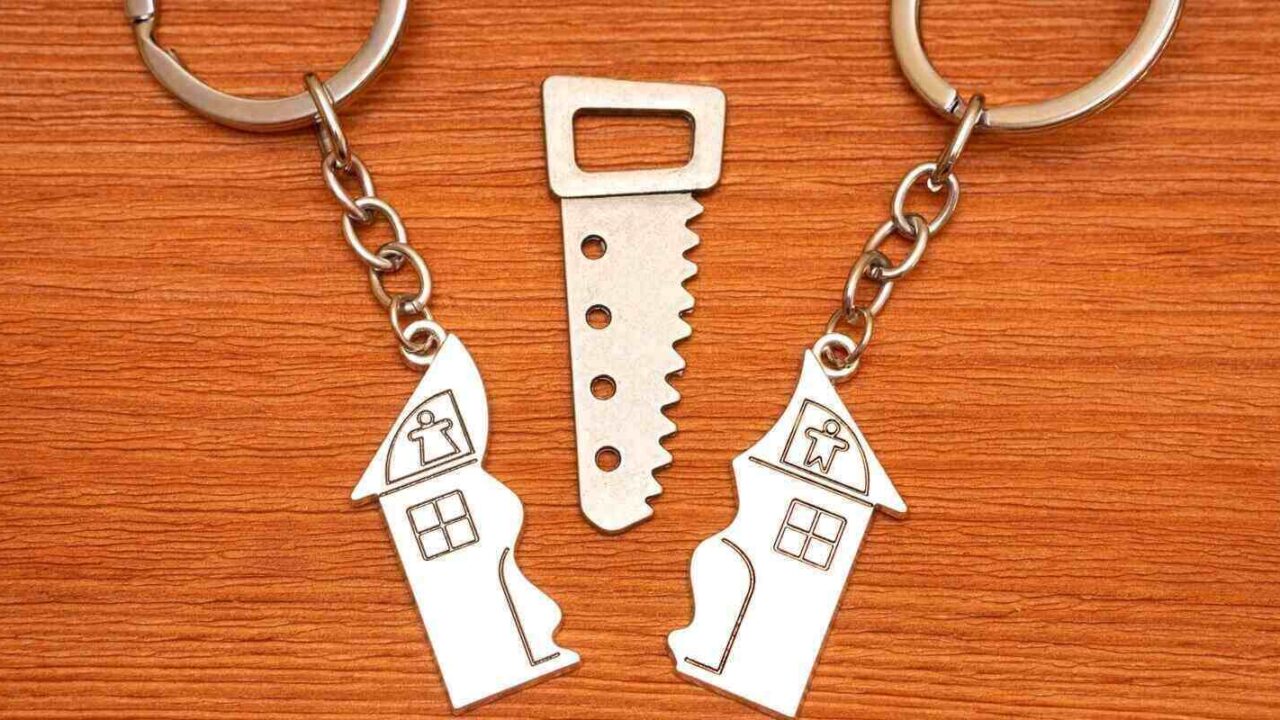 split house matching keychains with a small steel saw on a wooden table