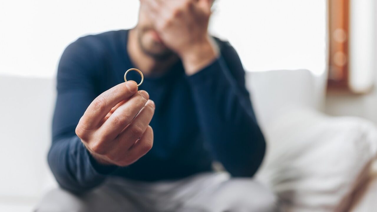upset man with engagement ring in hand