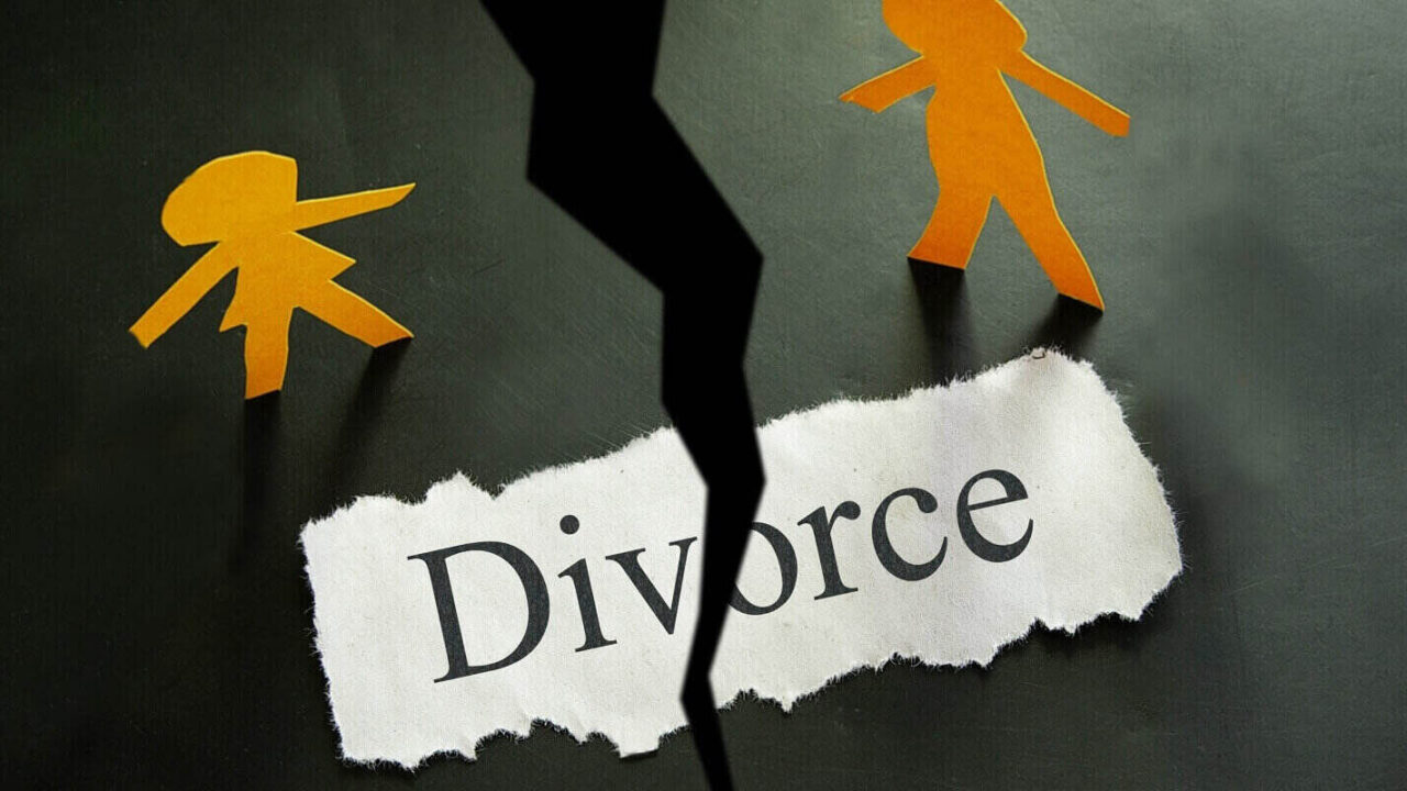 torn piece of paper with divorce text and paper couple figures