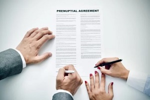 couple signing prenuptial agreement