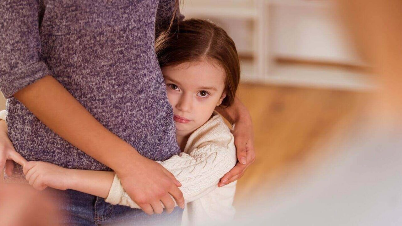 worried child hugging mom during quarrels between parents