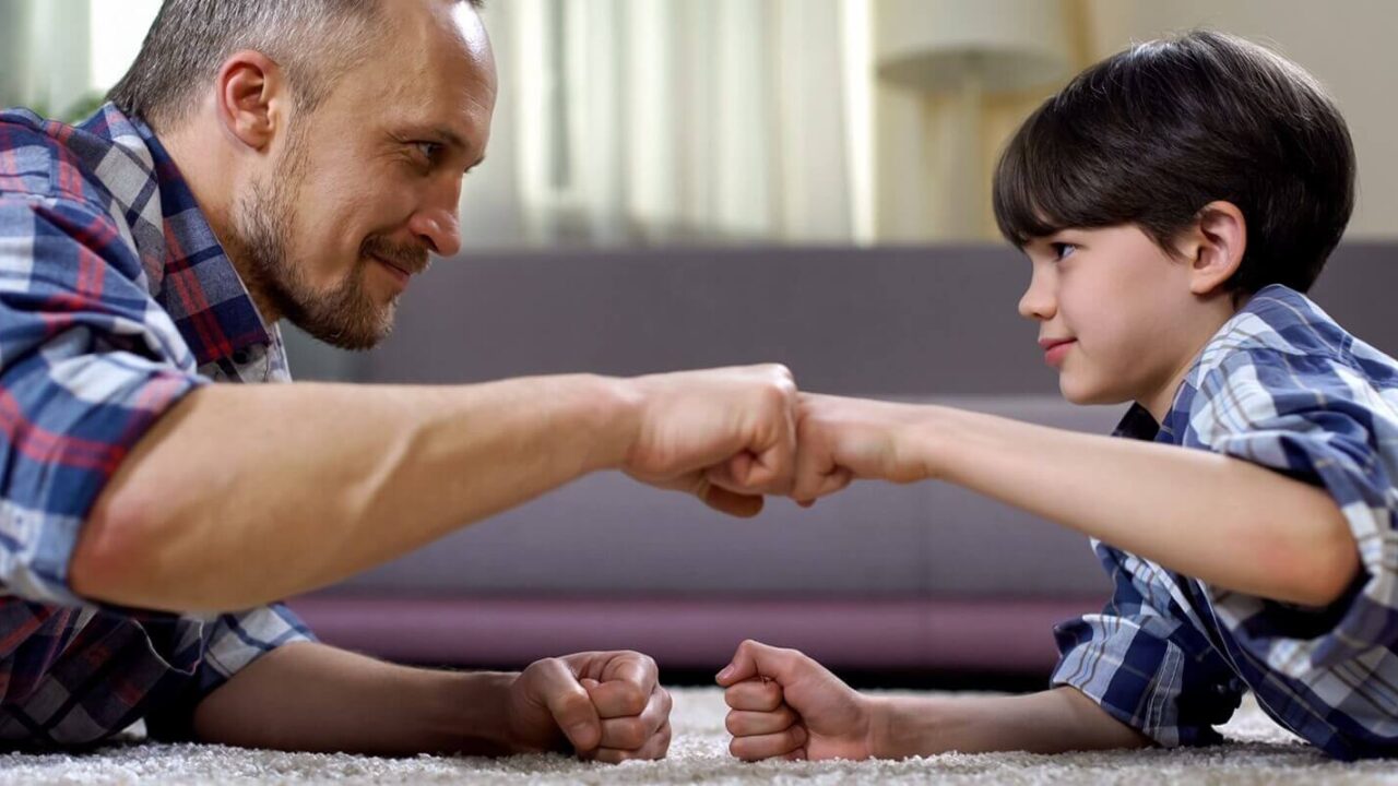 stepfather and child fist bumping, partnership greeting, happy childhood moment