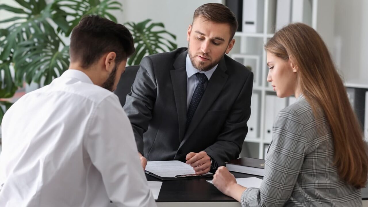 unhappy young couple visiting divorce lawyer in office
